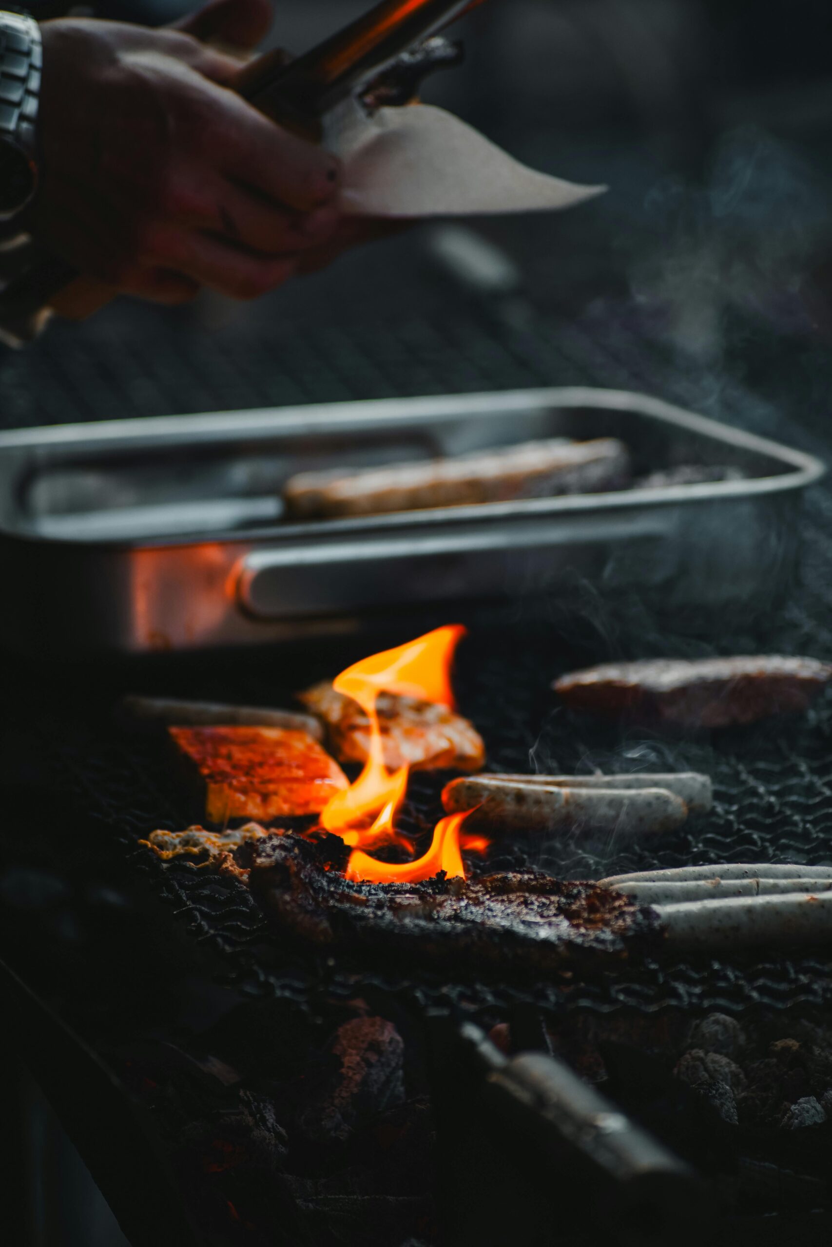 Close-up of sausages and meat grilling over a flame outdoors in Germany.